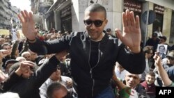 Le journaliste algérien Khaled Drareni est porté par des manifestants sur leurs épaules après avoir été brièvement détenu par les forces de sécurité à Alger, le 6 mars 2020.