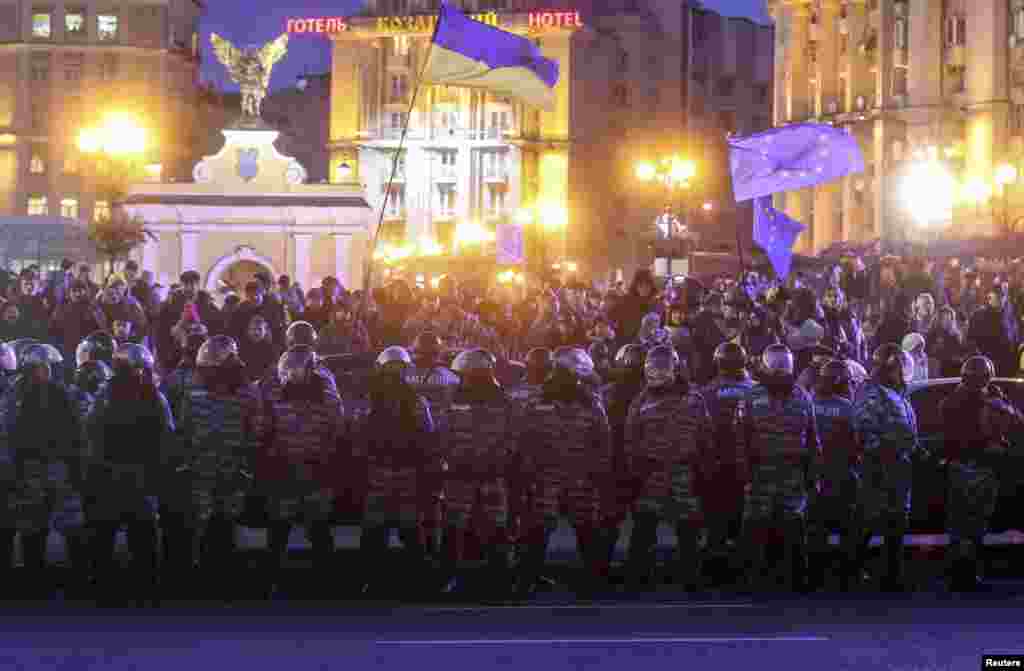 Police stand guard in front of protesters during a demonstration in support of EU integration at Independence Square in Kyiv, Nov. 29, 2013.