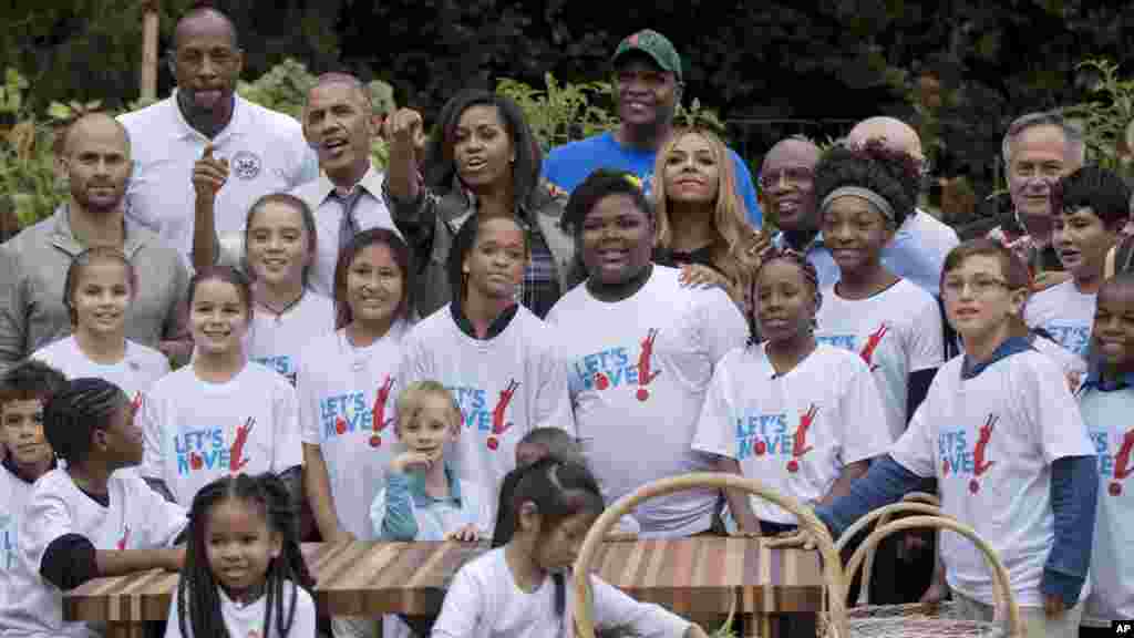 President Barack Obama and first lady Michelle Obama, joined by, from top left, former White House Senior Policy Adviser for Nutrition Policy Sam Kass, retired NBA basketball player Alonzo Mourning, the president, the first lady, farmer Will Allen, founder and CEO of Growing Power Inc., singer Ashanti and Al Roker of CBS, pose for a photograph with children and participants during the harvest of the White House Kitchen Garden on the South Lawn in Washington, Oct. 6, 2016.