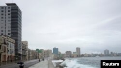 Un hombre camina en el malecón frente al mar durante el paso de la tormenta Eta, en La Habana, Cuba, el 8 de noviembre de 2020.