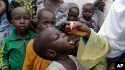 Un responsable de la santé administre un vaccin contre la poliomyélite aux enfants dans un camp de déplacés à Maiduguri, au Nigeria, le 28 août 2016.