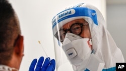 Un médico toma una prueba COVID-19 de un pasajero que llegó al aeropuerto de Duesseldorf, Alemania, el lunes 27 de julio de 2020.