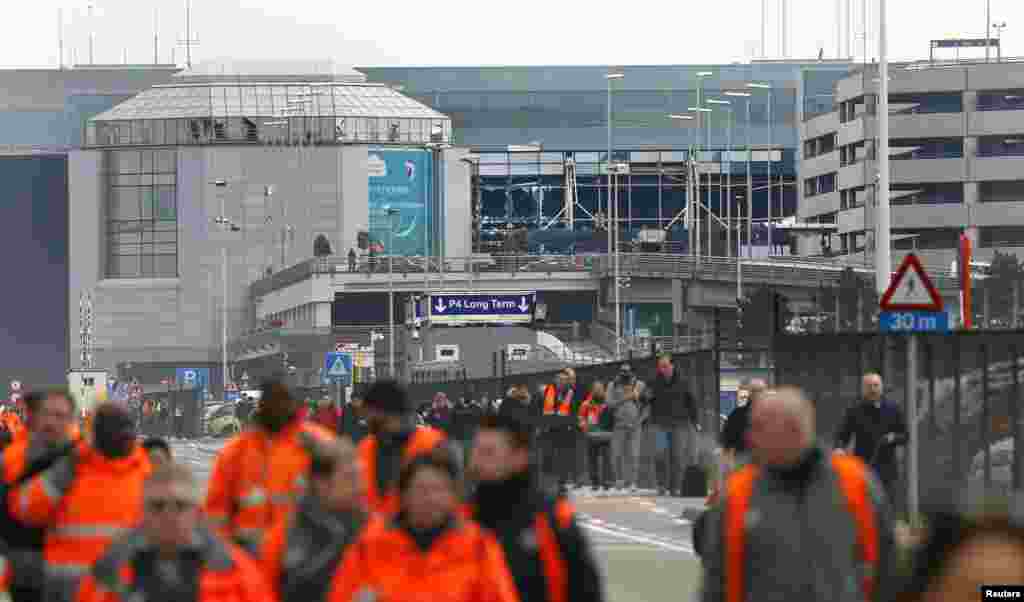 People leave the scene of explosions at Zaventem airport near Brussels, March 22, 2016.