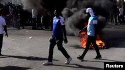 Neumáticos son quemados durante protestas en las calles de Puerto Príncipe exigiendo la renuncia del presidente Jovenel Moise, el 28 de febrero de 2021.