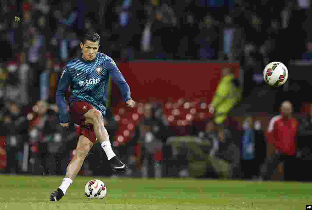 Cristiano Ronaldo du Portugal botte le ballon lors d'une séance d'échauffement avant le match de football international amical contre l'Argentine au stade d'Old Trafford, Manchester, en Angleterre, mardi 18 novembre 2014.