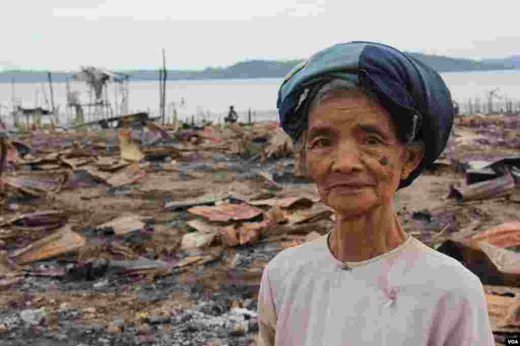 2012年11月,一位妇女站在被焚毁的若开邦穆斯林社区皎漂(Kyauk Phyu)前。 (D. Schearf/VOA)