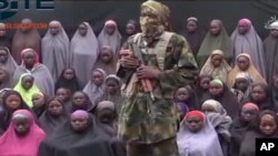Photographie extraite d'une vidéo montrant un soldat de Boko Haram devant un groupe de filles qui pourraient être les 276 jeunes filles de l'école de Chibok, le 14 août 2016.