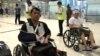 Cambodian opposition​ CNRP lawmakers Nhay Chamroeun (left) and Kong Saphea (right) are seen arriving in wheelchairs at Bangkok airport on Tuesday, October 27, 2015 after being beaten by protesters in Phnom Penh, Cambodia on Monday. (Courtesy of Nhay Chamroeun)