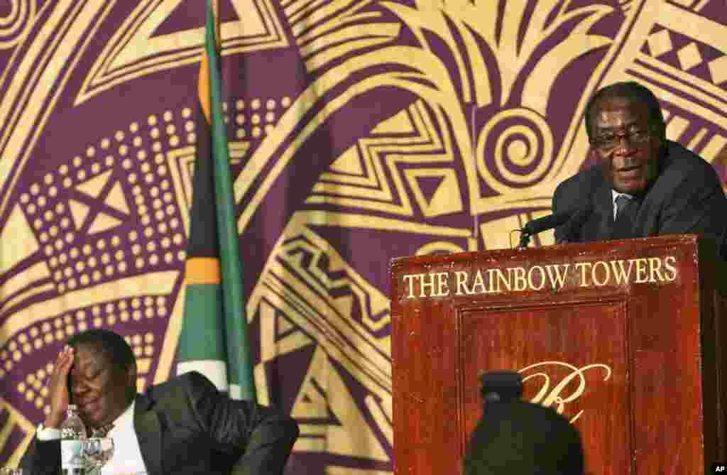 President Robert Mugabe, right, delivers his speech while the new Prime Minster Morgan Tsvangirai, left listens at the signing of the power sharing deal in Harare Monday, Sept, 15, 2008. Thousands of supporters of Zimbabwe's rival political parties pressed into the compound where their leaders just signed an historic power-sharing deal to cheer the leaders.