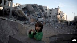 A Palestinian boy stands next to the rubble of Hamas' Al-Aqsa TV station building which was hit Monday by Israeli airstrikes Monday in Gaza City, Nov. 13, 2018. 