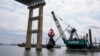ARCHIVO - Trabajadores retiran los restos del puente Francis Scott Key derrumbado, el jueves 25 de abril de 2024, en Baltimore