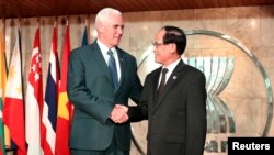 U.S. Vice President Mike Pence (L) is greeted by former ASEAN Secretary-General Le Luong Minh.