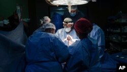 Doctores operan a un paciente en el hospital Mártires de Al-Aqsa, en Deir al-Balah, Gaza, el 17 de marzo de 2024. Un equipo internacional de médicos pasó dos semanas trabajando en el recinto hospitalario en medio de una escasez de suministros.