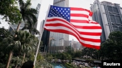 一名男子手持美国国旗在港岛参加反对香港警察对反送中示威者过度使用暴力的游行。（2019年7月28日）