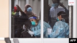 Petugas medis melakukan tes Covid-19 di sebuah kompleks hunian di Melbourne, Australia, 6 Juli 2020. (Foto: dok).