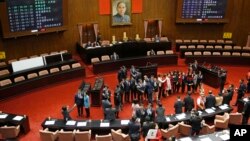 FILE - Under a portrait of Dr. Sun Yat-sen, the founding father of the Republic of China, Taiwan's Democratic Progressive Party (DPP) legislators pose for photos after being sworn in on the legislature floor in Taipei, Taiwan on Feb. 1, 2016.