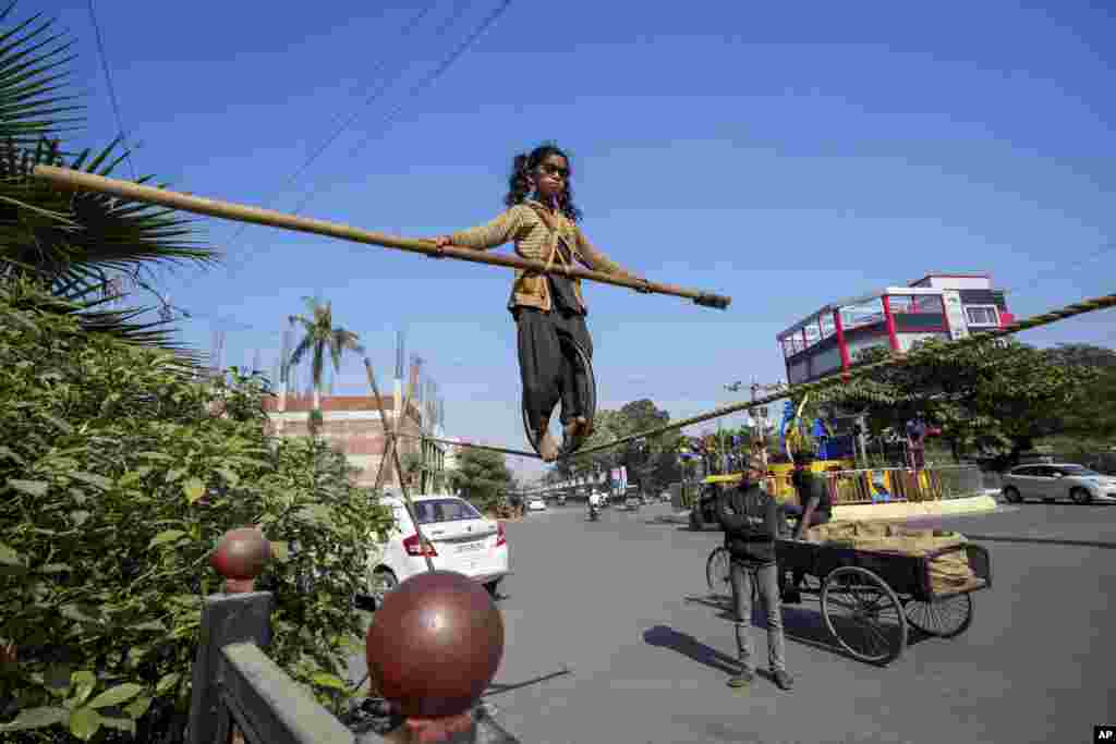 Maria, seorang gadis berusia enam tahun dari negara bagian Chhattisgarh, memamerkan keterampilan berjalan di atas tali untuk menarik sedekah dari orang-orang di pinggir jalan di Prayagraj, Uttar Pradesh, India. (AP) 