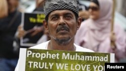 A Muslim protester holds up a sign during a protest against an anti-Islam film made in the U.S. mocking the Prophet Mohammad, outside the U.S embassy in Jakarta, September 21, 2012. 