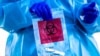 COVID Check Colorado site tester Pamela Deemie holds a bag after administering a COVID test at Echo Park Stadium on Dec. 30, 2020, in Parker, Colo.