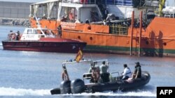 Des migrants se tiennent sur le pont de l'Aquarius alors que le navire entre dans le port de Valence, le 17 juin 2018.