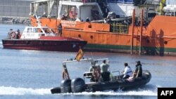 Des migrants se tiennent sur le pont de l'Aquarius alors que le navire entre dans le port de Valence, le 17 juin 2018.