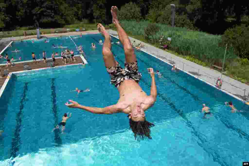 Leopold jumps into the water of the Freibad Wostra public open air pool in Dresden, eastern Germany.