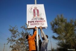 Los voluntarios cristianos decoran las calles con las imágenes del Papa Francisco, antes de su visita planificada a Irak, en Qaraqosh, Irak, el 22 de febrero de 2021.