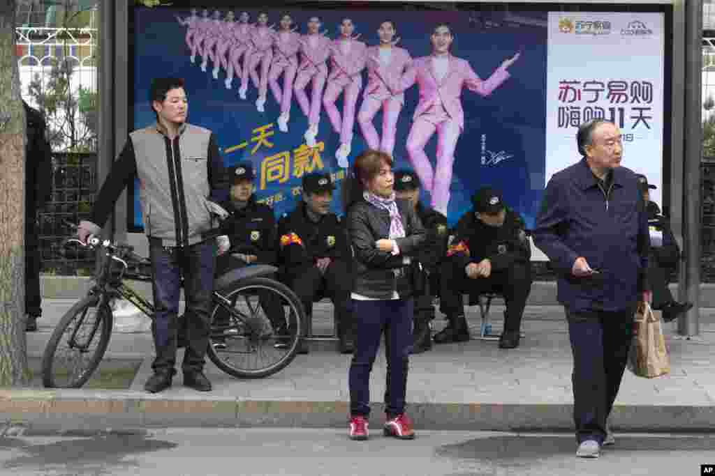 十九大期间北京街头坐着的的5名佩戴红袖章的安保人员,左侧还站着一个(2017年10月21日)。 这是北京高密度安保的缩影。大会期间北京安保措施空前,包括关闭夜店酒吧,禁止燃放鞭炮,实行交通管制,出动军人军车。据说还出动了被网民戏称为北京五大神秘组织的“朝阳群众”、“西城大妈”、“海淀网友”、“丰台劝导队”以及以学生为主的“网警志愿者”。