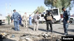 Pasukan keamanan Irak memeriksa lokasi serangan bom bunuh diri di Kut, 150 kilometer sebelah tenggara Baghdad (30/9). Serangan ini menewaskan sedikitnya 4 polisi setempat. 