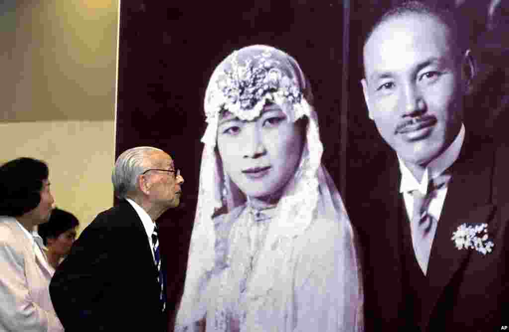 2003年,参观者在香港的图片展观看民国时期领导人蒋介石和宋美龄的结婚照。新娘宋美龄穿的是自己设计的中西合璧的婚纱。