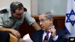 Israel's Prime Minister Benjamin Netanyahu speaks his military secretary Brigadier General Eliezer Toledano, left, during the weekly cabinet meeting at his office, in Jerusalem, Oct. 25, 2015. 