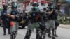Pasukan keamanan Hong Kong menembakkan gas air mata ke arah para demonstran pada aksi protes hari Minggu (24/5). 