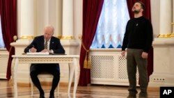 Президент США Джо Байден розписується у гостьовій книзі у Маріїнському палаці під час зустрічі із президентом України Володимиром Зеленським, 20 лютого 2023. AP Photo/Evan Vucci, Pool