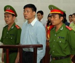 Blogger Truong Duy Nhat (C) stands trial on March 4, 2014.