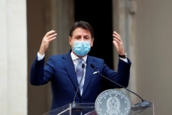 Italian Prime Minister Giuseppe Conte wearing a protective face mask gestures as he speaks during a news conference on government's new anti-COVID-19 measures, at Chigi Palace in Rome, Oct. 25, 2020.