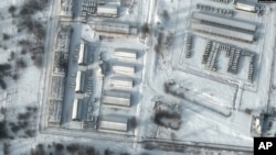 Esta imagen satelital muestra un primer plano de vehículos blindados de transporte de personal y camiones en las instalaciones de almacenamiento de Klimovo en Rusia, 13 kilómetros al norte de la frontera entre Rusia y Ucrania, el 19 de enero de 2022.