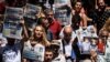FILE - Protesters hold pictures of jailed Reporters Without Borders representative Erol Onderoglu, journalist Ahmet Nesin and rights activist Sebnem Korur Fincanci as they shout slogans in front of the Pro Kurdish Ozgur Gundem newspaper's headquarters, in Istanbul, June 21,2016.