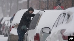 Un automovilista limpia de nieve su vehículo el jueves 3 de febrero de 2022, en Indianápolis, EE. UU.