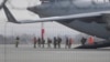 Efectivos de la 82ª División Aerotransportada del Ejército de Estados Unidos descargan vehículos de un avión tras arribar el domingo 6 de febrero de 2022 al aeropuerto Rzeszow-Jasionka, en el sureste de Polonia. 