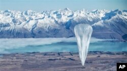 Sebuah balon Google terbang melewati pegunungan Alpen Selatan dengan latar belakang Tekapo, Selandia baru. Balon-balon ini terbang di stratosfer dan memancarkan sinyal Internet ke Bumi. (AP/Jon Shenk) 
