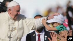 El Papa Francisco bendice a un niño durante una misa en Abu Dhabi, Emiratos Árabes Unidos, el martes 5 de febrero de 2019. 