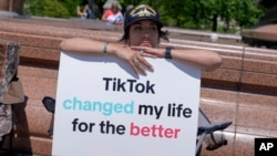 Una creadora de contenidos de TikTok, sostiene un cartel "TikTok cambió mi vida para bien" frente al Capitolio de EEUU, en Washington, el 23 de abril de 2024