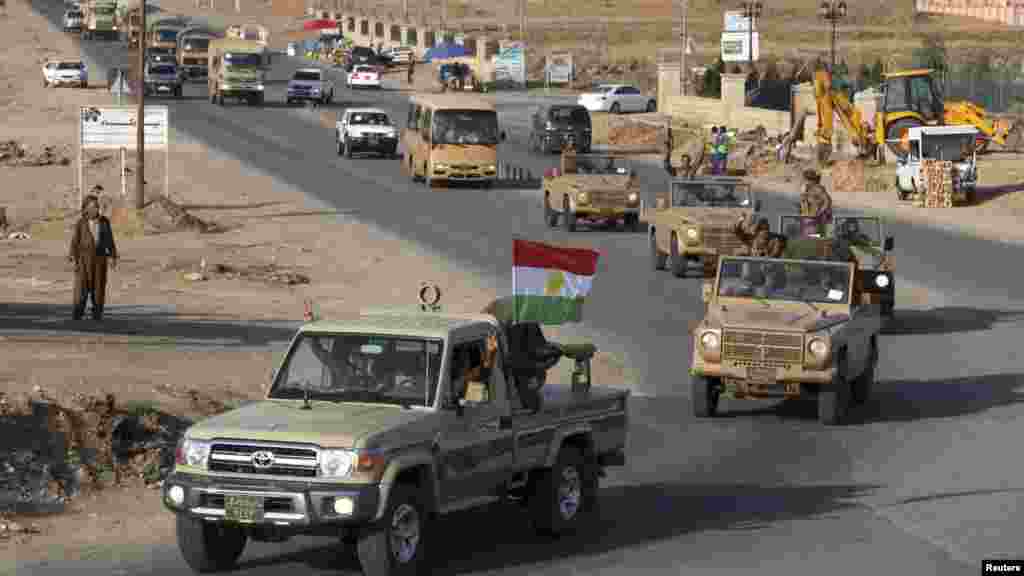 A convoy of Kurdish peshmerga fighters drives through Irbil after leaving a base in northern Iraq, on their way to Kobani, Syria, Oct. 28, 2014.