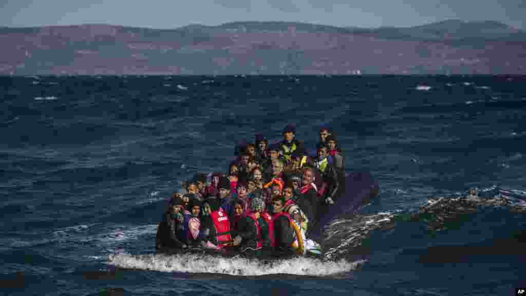 Des migrants afghans dans un bateau gonflable bondé approchent l'île grecque de Lesbos après avoir traversé, par un mauvais temps, la mer Egée voir de la Turquie, 28 octobre 2015. 