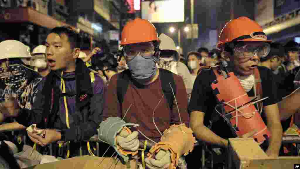 Protesters guard makeshift barricades at a pro-democracy protest encampment in the Mong Kok district of Hong Kong early, Oct. 19, 2014.