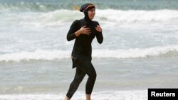 Seorang perempuan Muslim mengenakan burkini di pantai (foto: ilustrasi).