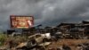 FILE - A burnt car and marketplace, allegedly destroyed by separatist fighters, is seen in the Southwest province in Buea, Cameroon, Oct. 3, 2018. In light of the conflict raging since 2017, hundreds of singers are organizing to perform around Cameroon to call for a cease-fire.