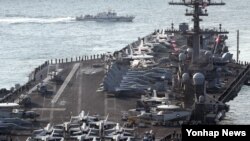 지난 3월 15일 한국 부산항에 도착한 미국 해군의 핵추진 항공모함 칼빈슨호 갑판 위에 항공기와 승조원들이 도열하고 있다. 1982년 취역한 칼빈슨호는 배수량 10만t에 크기가 길이 333ｍ, 폭 77ｍ에 달해 '떠다니는 군사기지'로 통한다. F/A-18 슈퍼호넷 전투기, E-2C 호크아이 조기경보기, EA-18G 그라울러 전자전기, MH-60S 시호크 해상작전헬기 등 약 80대의 항공기를 탑재해 웬만한 중소 국가의 공군력 전체와 맞먹는 전력을 갖췄다. 