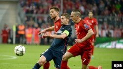 Xabi Alonso de Bayern, à gauche, et son co-équipier Franck Ribéry, à droite, aux prises avec Gabi de Madrid au cours du match retour de demi-finale de football de la Ligue des Champions entre le Bayern Munich et l’Atletico Madrid à Munich, Allemagne