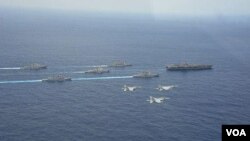 4月28日在沖繩附近海域，日本兩艘軍艦和兩架F15戰機參加美國核航母“卡爾·文森”號為首的美軍戰艦群和航母搭載機聯合軍演時的布陣航行、飛行環節（日本航空自衛隊提供）